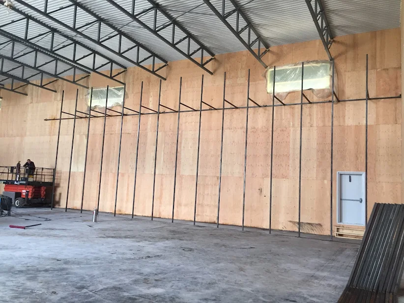 Intérieur d'un hangar industriel en construction — murs de bois et structure métallique