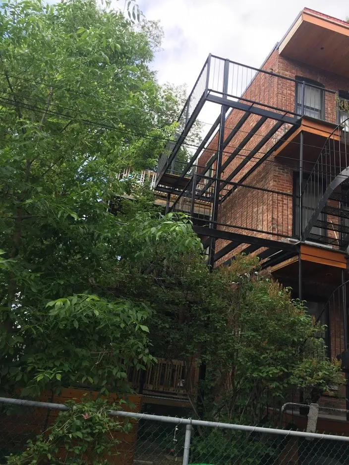 Escalier extérieur en acier noir — installation sur immeuble en brique