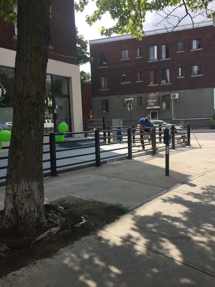 Installation d'une rampe d'accès en acier noir devant un commerce