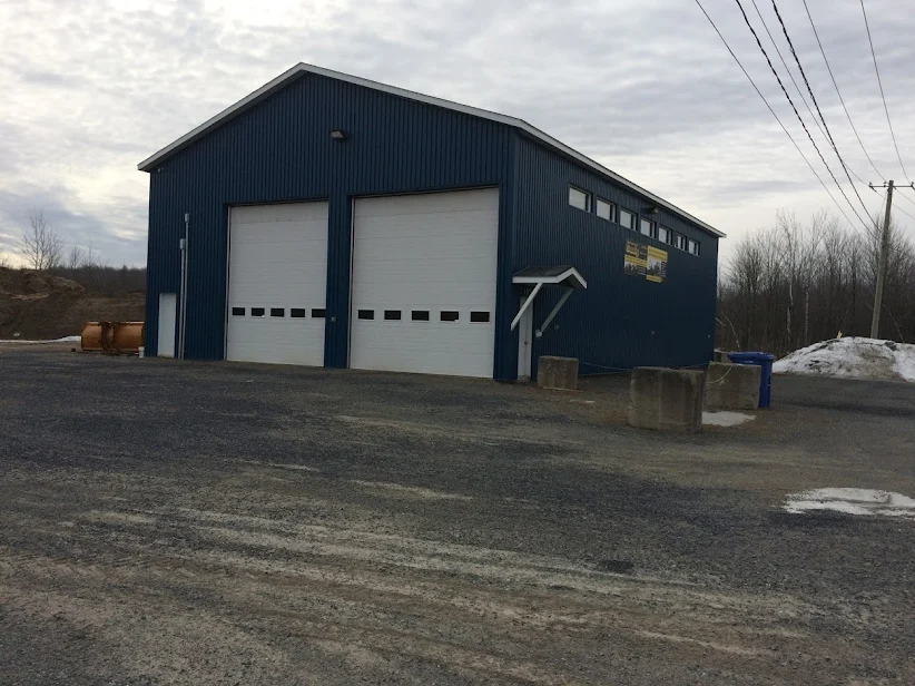 Bâtiment commercial bleu avec portes de garage — construction neuve complétée